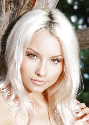 Beautiful blonde Adelia A posing naked by the tree